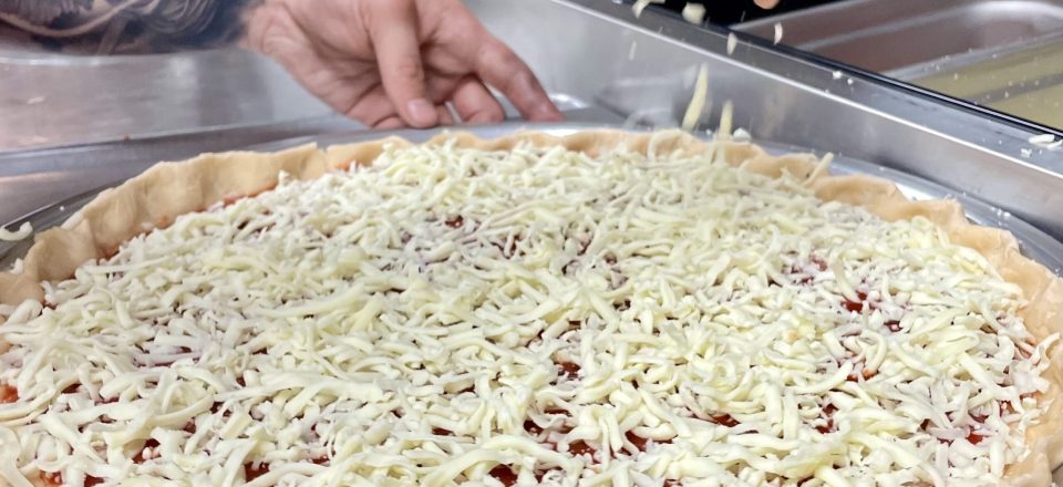 Sprinkling cheese on pizza